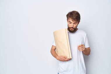 Elinde paket olan bir adam izole edilmiş alışveriş geçmişini paketliyor.