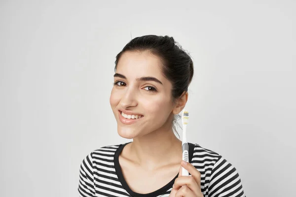 Χαρούμενη γυναίκα σε ριγέ T-shirt οδοντόβουρτσα στο χέρι απομονωμένη φόντο — Φωτογραφία Αρχείου