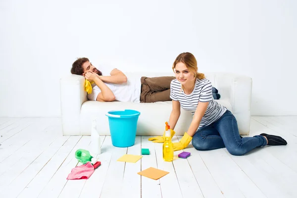Man and woman near the sofa room cleaning protective gloves — Stock Photo, Image