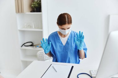 Hastane çalışanlarının masasında oturan bir hemşire.