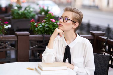 Elinde kitap olan bir öğrenci temiz hava eğitiminde yürüyor.