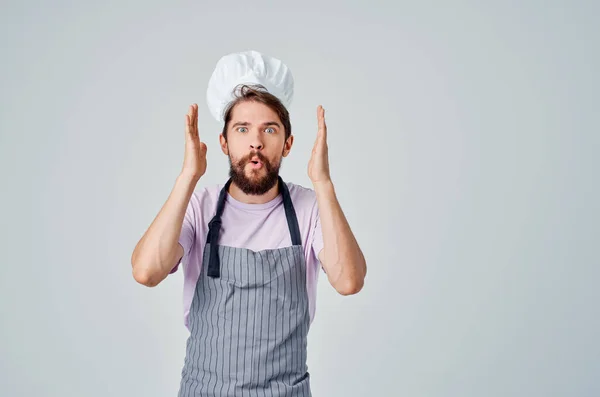 Emocionální vousatý muž v zástěře pracující v kuchyni poskytující služby — Stock fotografie