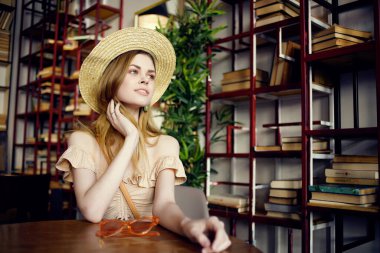 Kafe modasına uygun bir kitabı olan güzel bir kadın.