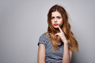 Güzel bir kadın elinde saç makyajı tutarak eğlenceli bir moda arkaplanı oluşturuyor.