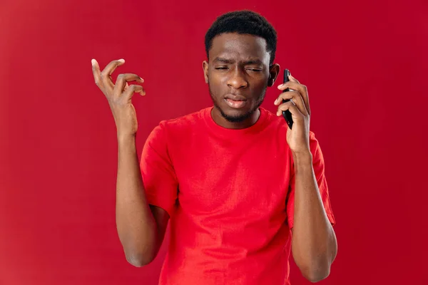 Uomo che parla al telefono in uno studio di comunicazione t-shirt rossa primo piano — Foto Stock