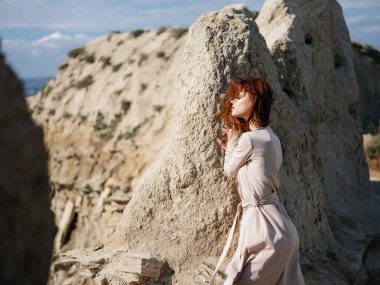 Taşın yanındaki güzel kadın yaşam tarzını sallıyor.