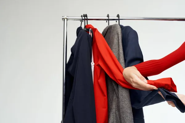 Bela mulher em uma jaqueta vermelha perto do guarda-roupa de fundo luz de varejo — Fotografia de Stock