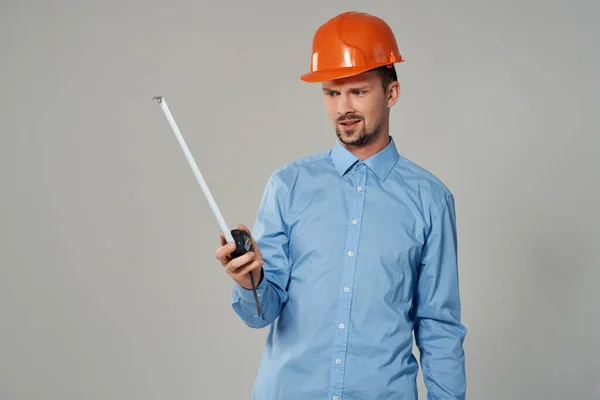 Man in de bouw uniform blauwdrukken bouwer licht achtergrond — Stockfoto