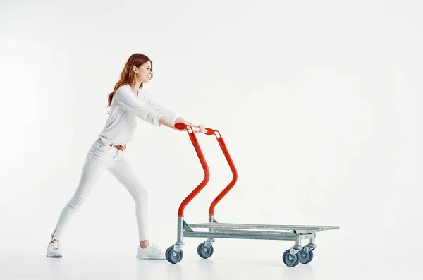 Donna equitazione carrello trasporto merci supermercato luce sfondo — Foto Stock