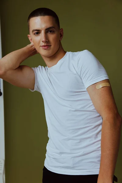 Homem em um branco t-shirt band-aids mão vacina paciente passaporte — Fotografia de Stock
