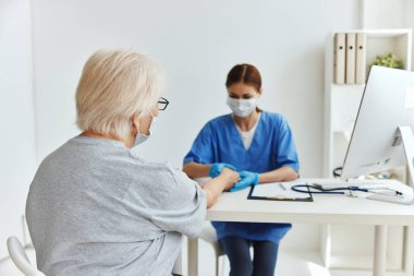 Yaşlı kadın ve doktor hasta muayene ofisi