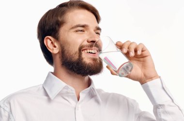Beyaz gömlekli adam arka planda su içiyor. Yüksek kalite fotoğraf