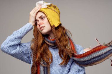 Kadın boyun atkısı ve arka planında şapka var.