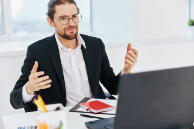 Takım elbiseli bir adam ofis bilgisayarında çalışıyor.
