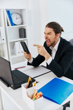Resepsiyondaki adam telefon aracılığıyla iletişim kuruyor.