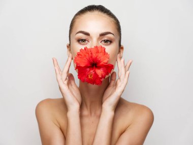 Gözleri kapalı, omuzları çıplak kırmızı çiçek dudaklı bir kadın.