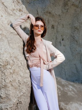 Güzel bir kadın kumların üzerinde poz veriyor.