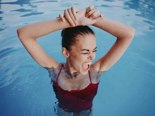 Mulher de fato de banho vermelho mãos perto de face piscina resto — Fotografia de Stock