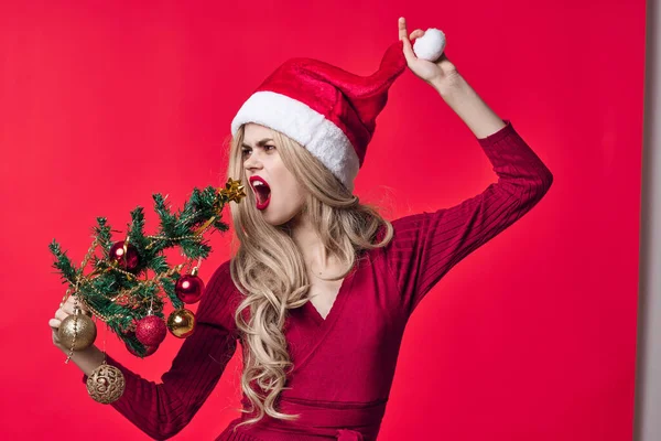 Žena v červených šatech vánoční strom hračky dovolená růžové pozadí — Stock fotografie