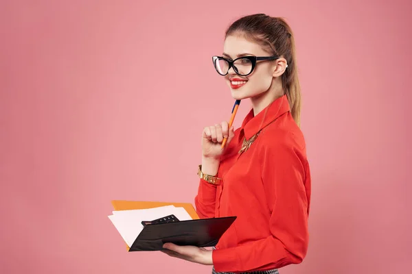 Mulher de negócios em camisa vermelha com bloco de notas em mãos emoções fundo rosa — Fotografia de Stock