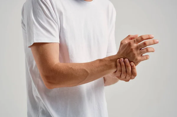 Homem de t-shirt branca dor nas articulações problemas de saúde das mãos — Fotografia de Stock
