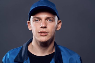 İş üniformalı adam mavi şapkalı.