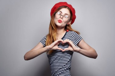 Kırmızı şapkalı neşeli kadın poz veriyor.