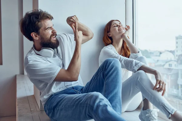 Una joven pareja sentada en el alféizar de la ventana romance alegría — Foto de Stock