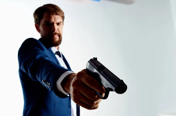 O homem de fato Agente secreto com uma arma nas mãos de um fundo de luz do crime — Fotografia de Stock