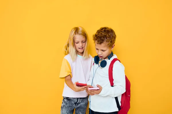Niedlichen Kinder verwenden Gadgets mit Kopfhörer isolierten Hintergrund — Stockfoto