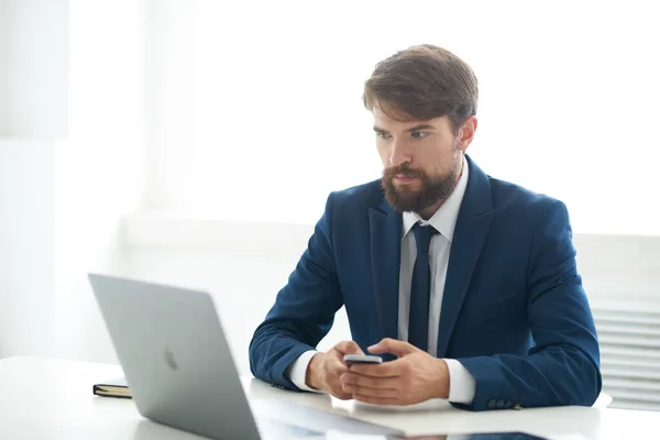 Üzletember öltönyben nyakkendővel ül egy asztalnál egy laptop kommunikáció előtt — Stock Fotó