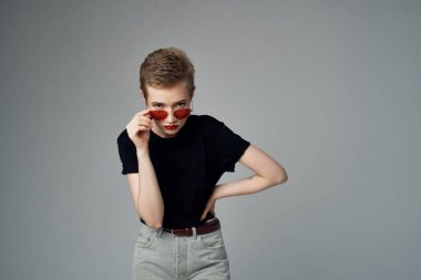 Kısa saçlı bir kadının el hareketi. Kırmızı dudaklar göz alıcı, izole bir arka plan.