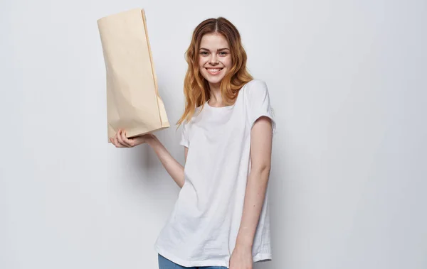 Frau in weißem T-Shirt mit Verpackung von Lebensmitteln — Stockfoto