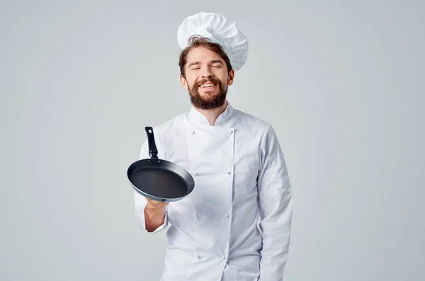 Um homem em uma cozinha de cozinha de panela uniforme de chefs Profissional — Fotografia de Stock