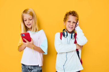 Okul çantalı genç bir çocuk ve kız. Telefon, eğlence, iletişim, izole bir geçmiş.