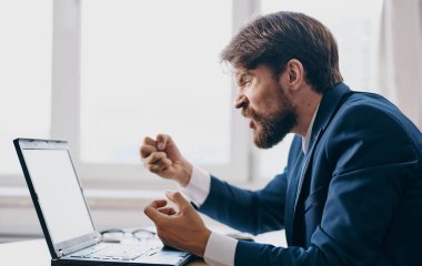 Bir dizüstü bilgisayarın önünde oturan adam finans şebekesi uzmanı.