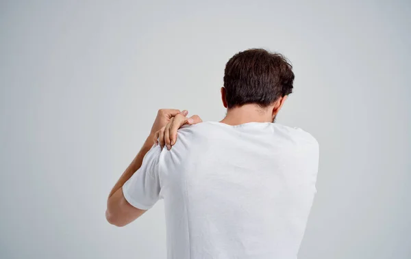 Man holding neck arthritis health problems light background — Stock Photo, Image