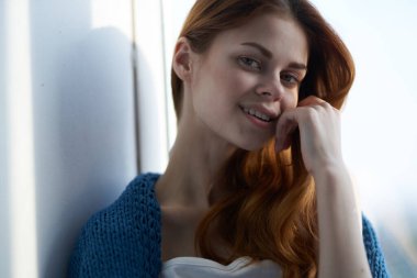 Pencere kenarında oturan mavi ekoseli bir kadın Yaşam tarzıyla