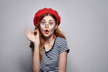 Kırmızı şapkalı neşeli kadın makyaj kıyafeti giymiş.