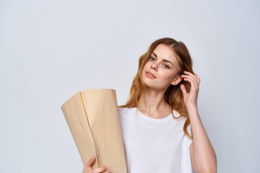 Elinde bir paketle neşeli bir kadın. Arka planda alışveriş yapıyor.