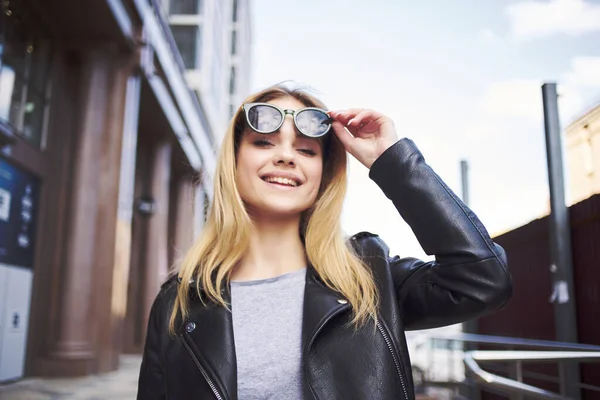 Pretty woman in leather jacket walking down the street — Stock Photo, Image