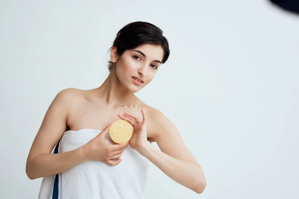 Mooi brunette in een handdoek spons van wat gezondheid cosmetologie — Stockfoto