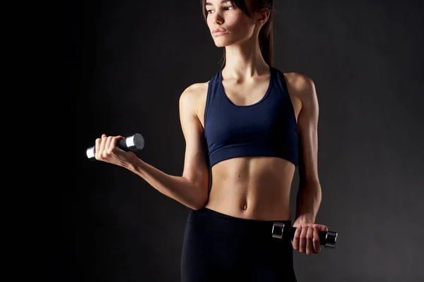 Mancuernas de ejercicio de fitness mujer delgada en las manos de fondo aislado fuerte — Foto de Stock