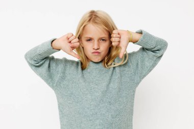 Süveter giymiş gülümseyen küçük bir kızın portresi, çocukların yaşam tarzını bozuyor.