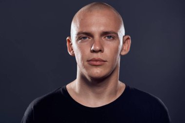 Siyah kazaklı kel kafalı neşeli bir adamın yakın çekimi.