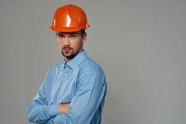 Construtor masculino em uma camisa azul emoções profissional isolado fundo — Fotografia de Stock