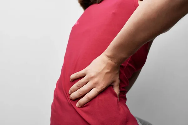 Mujer en camiseta roja dolor en las articulaciones problemas de salud tratamiento — Foto de Stock