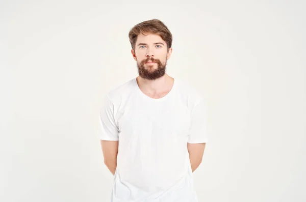 Χαριτωμένο γενειοφόρος άνδρας σε λευκό t-shirt στούντιο μόδας φως φόντο — Φωτογραφία Αρχείου