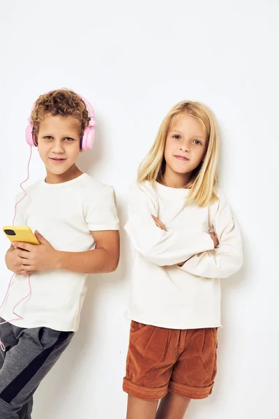 Obrázek chlapce a dívky usmívá s telefonem v ruce módní izolované pozadí — Stock fotografie