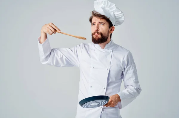 요리사의 제복을 입은 한 남자가 가벼운 서비스업 장비를 갖추고 있는 모습 — 스톡 사진